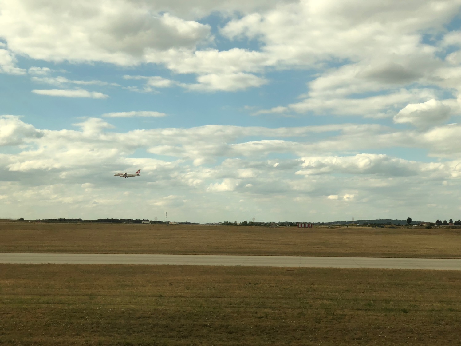 an airplane flying over a runway