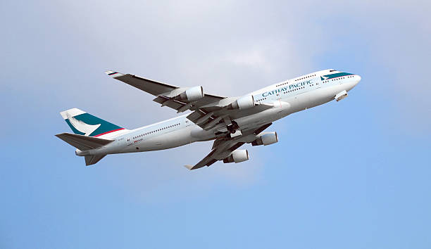 Commercial Airplane flying in the sky IS Caption: Hong Kong, China - August 10, 2013: Cathay Pacific Boeing 747 departure from the Hong Kong International Airport. Cathay Pacific is the international flag carrier of Hong Kong. cathay pacific stock pictures, royalty-free photos & images