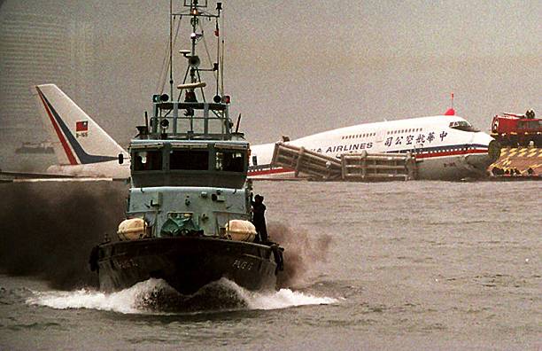 Police launch speeds by China Airlines flight 605 sitting half-submerged in Hong Kong's Victoria Harbor after the Boeing 747 ran off the runway 04...