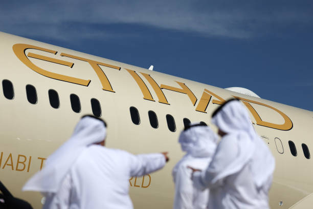 Visitors in front of a Boeing Co. 787-9 Dreamliner passenger aircraft, operated by Etihad Airways, at the Dubai Air Show in Dubai, United Arab...