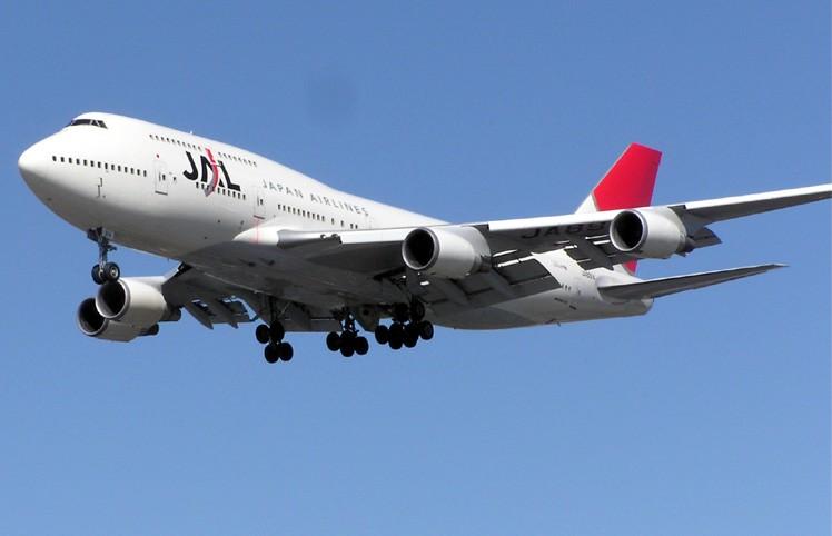 A Boeing 747-400 aircraft in mid-air, with blue sky in the background