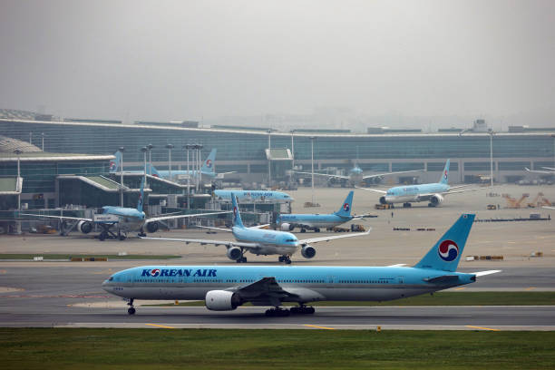 Boeing Co. 777-300 passenger aircraft, operated by Korean Air Lines Co., bottom, taxies on the tarmac at Incheon International Airport in Incheon,...