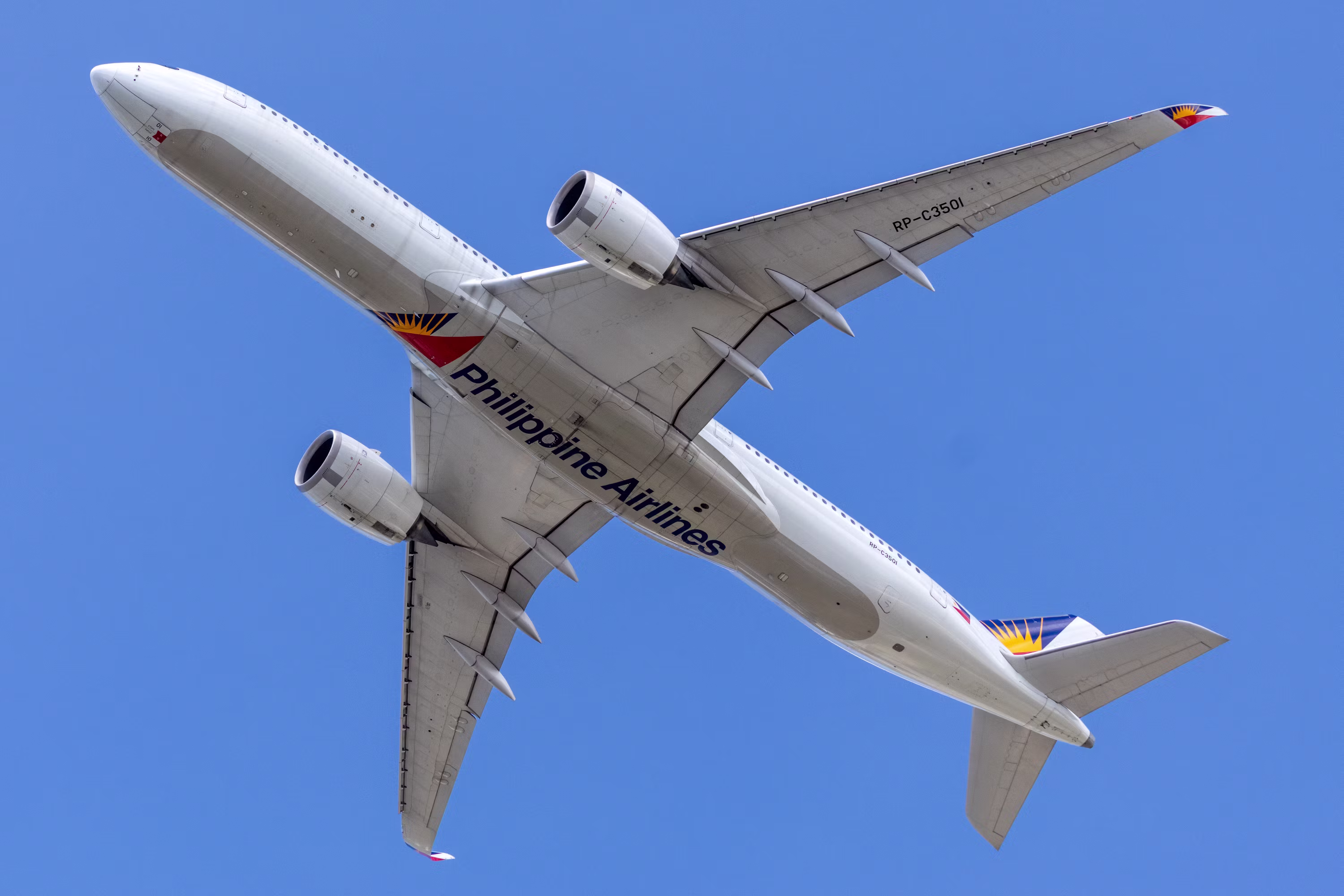 A philippine airlines airplane flying in a clear blue sky.