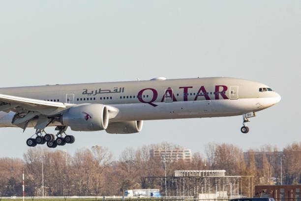 Qatar Airways Boeing 777-300 aircraft as seen on final approach flying and landing next to the highway road in Amsterdam Schiphol AMS EHAM airport in...