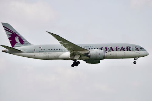 Free Qatar Airways Boeing 787 Dreamliner flying in clear skies. Stock Photo