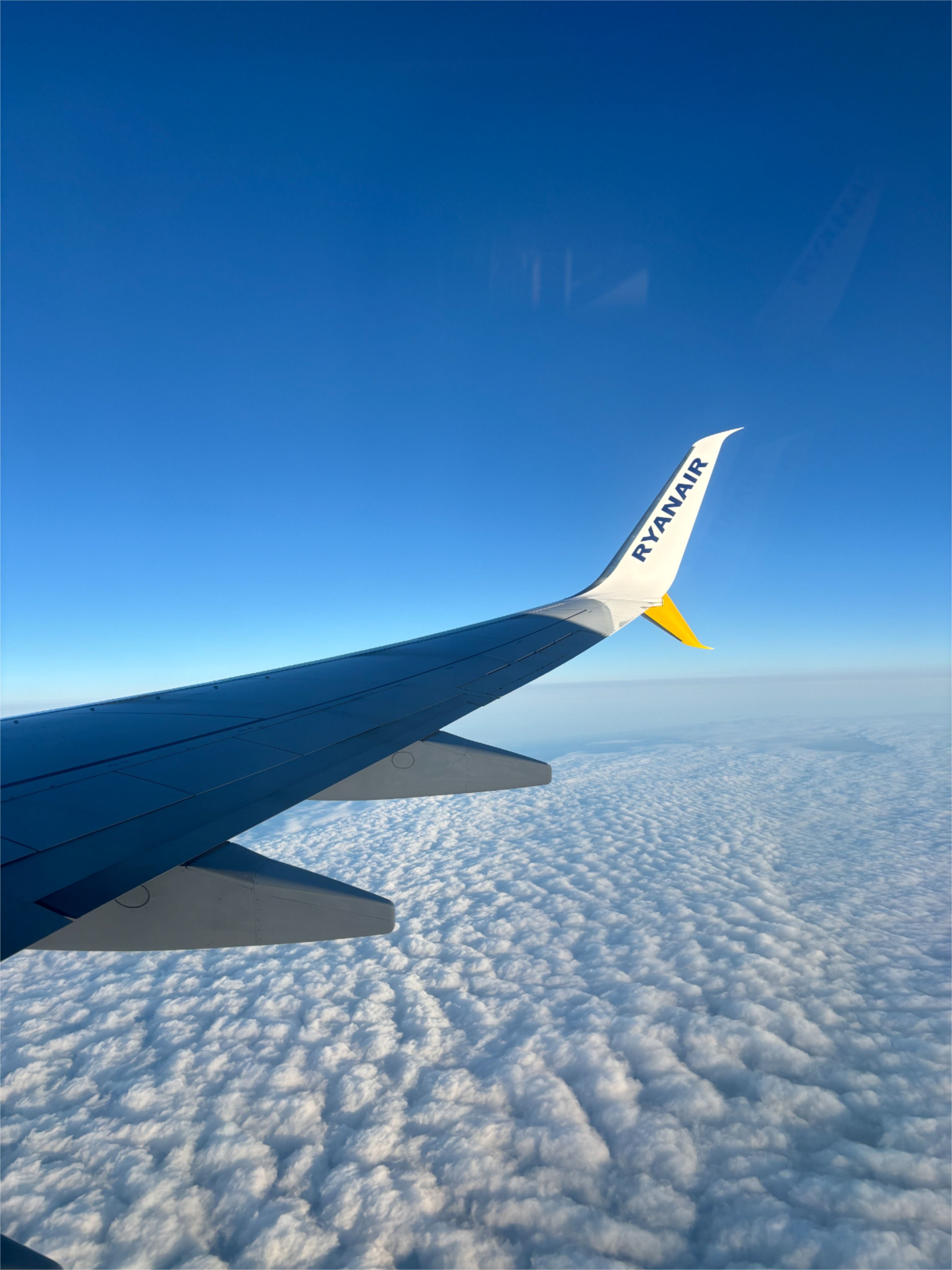 the wing of an airplane flying above clouds