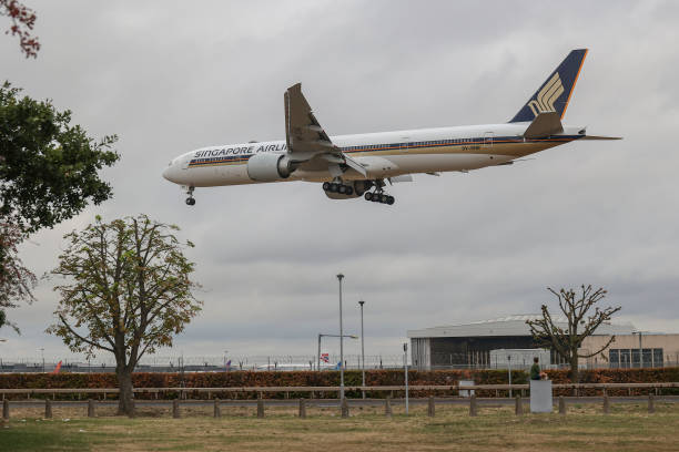 Singapore Airlines Boeing 777 aircraft as seen on final approach flying over the houses of Myrtle Avenue in London, a famous location for plane...