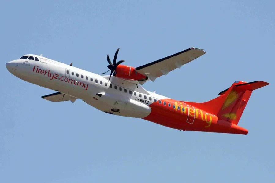 Firefly ATR 72-500 aircraft with orange and white livery flying in the sky.