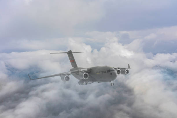 US Air Force C-17 Globemaster III transport aircraft. Flying over clouds. US Air Force C-17 Globemaster III transport aircraft. USAF  C-17 jet transport airlifter. c 17 globemaster stock pictures, royalty-free photos & images