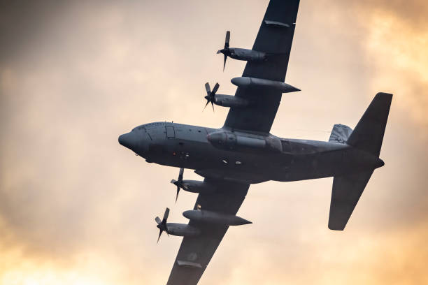 lockheed c-130 hercules military airplane flying in mid air during sunset - c 130 transport aircraft stock pictures, royalty-free photos & images