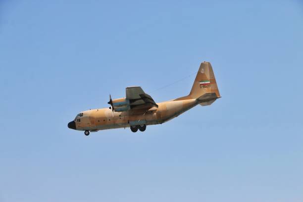 Flying Hercules C-130 of the Iranian Army The flight of Lockheed C-130 Hercules of Iranian army in the blue sky c 130 landing stock pictures, royalty-free photos & images