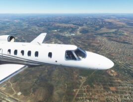 Cessna Citation CJ4 flying over suburban and mountainous terrain in clear skies