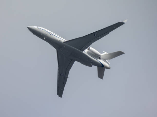RAAF Dassault 7X Flying A Royal Australian Air Force Dassault Falcon 7X plane, registration A56-001, taking off from the third runway of Sydney Kingsford Smith Airport and heading to Canberra. This image was taken from the 10th floor rooftop of a public carpark at the domestic terminal on a sunny and partly cloudy afternoon on 16 November 2024. dassault falcon 7x stock pictures, royalty-free photos & images