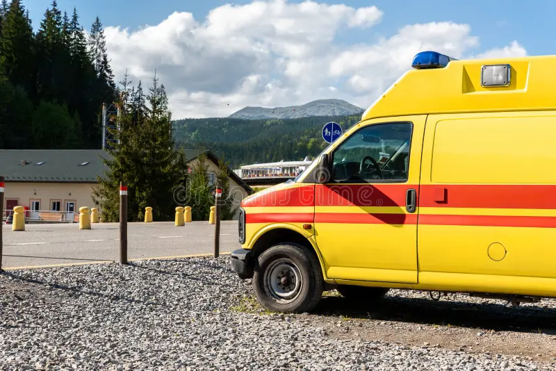 Side view of yellow ambulance rescue ems van car parked near countryside rural road at highland mountain resort area. Paramedic first aid help service vehicle against alpine forest landscape. Ambulance car side view stock images, royalty-free photos and pictures
