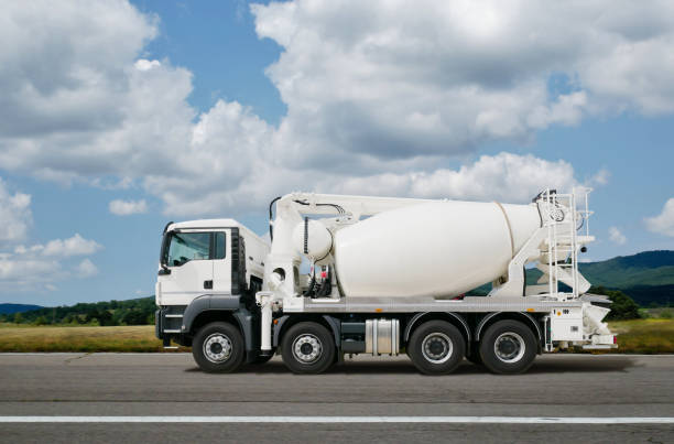 Cement mixer on the road Side view of an white cement mixer on the road. concrete mixer truck stock pictures, royalty-free photos & images