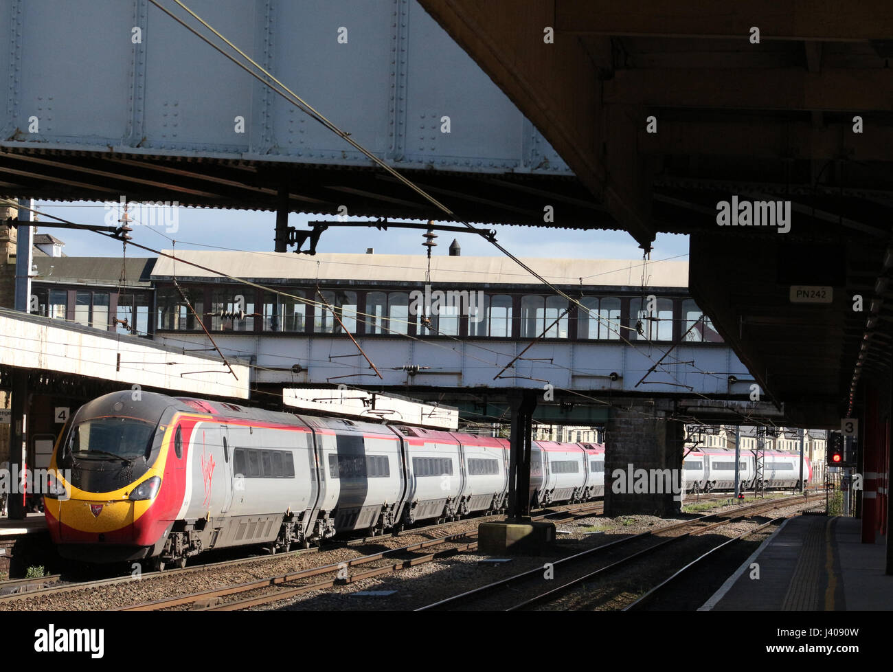 Class 390 Pendolino electric multiple unit train in Virgin West Coast livery departing from Lancaster railway station - Stock Image