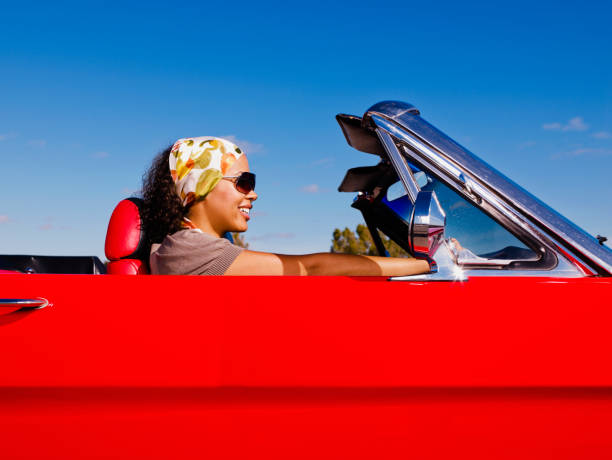 mixed race woman driving red convertible - convertible car side view stock pictures, royalty-free photos & images