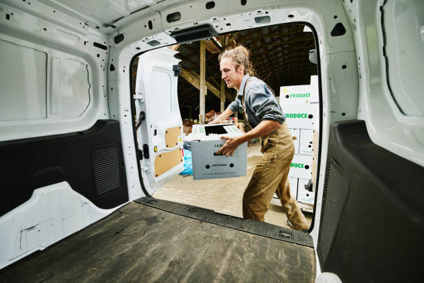 wide shot of farmer putting freshly packed csa boxes into delivery van - delivery truck side view stock pictures, royalty-free photos & images