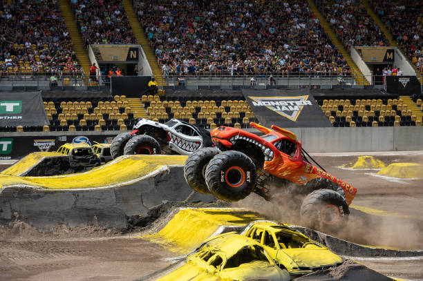 July 2023, Saxony, Dresden: : Monster truck "MONSTER MUTT DALMATIAN" and "EL TORO LOCO" jumping over ramps at the monster truck show "Monster Jam" at...
