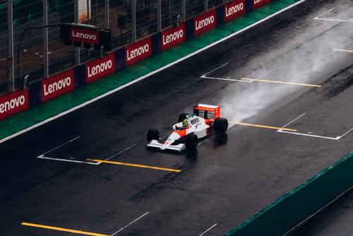 Free A classic Formula 1 car races on a wet track at Interlagos, Brazil, leaving a trail of spray behind. Stock Photo