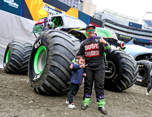 Adam Anderson, with his monster truck Grave Digger, poses for a picture with three year old Roman Bullock of Wrentham at the Monster Jam at Gillette...