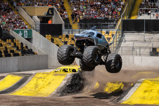 July 2023, Saxony, Dresden: The monster truck "MEGALODON" with driver Charlie Pauken jumps over a ramp at the monster truck show "Monster Jam" at the...
