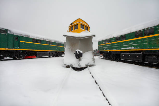 Snowplow train (Snow removal train) with railroad snow removal equipment for cleaning tracks ans rails from snow stays on the station with other locomotives in cold winter day. Snowplow train (Snow removal train) with railroad snow removal equipment for cleaning tracks ans rails from snow stays on the station with other locomotives in cold winter day. train plowing through snow storm stock pictures, royalty-free photos & images