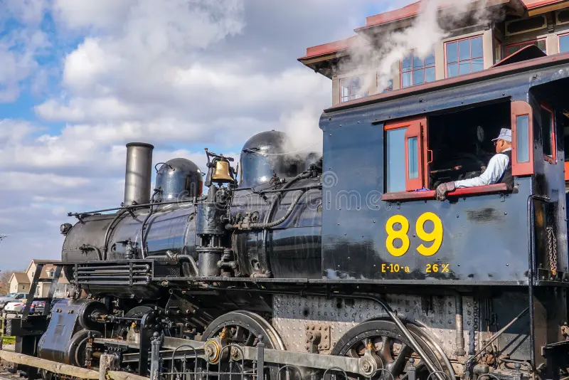Strasburg, Pennsylvania - December, 2019: Side view of an old steam locomotive engine with an engineer in the pilot window. Steam train side view stock images, royalty-free photos and pictures