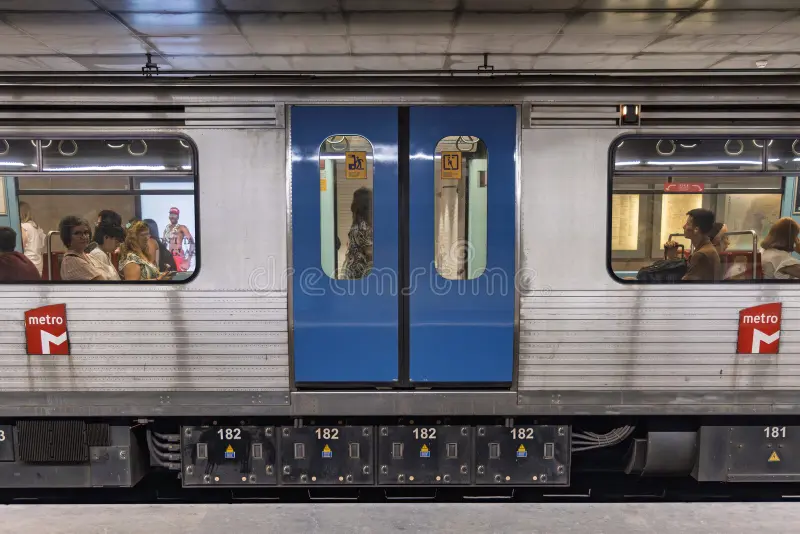 Side view of a Lisbon Metro train car stopped at a station. Passengers are visible through the windows, next to the blue double doors. Lisbon, Portugal. 1 August 2025. Side subway train view stock images, royalty-free photos and pictures