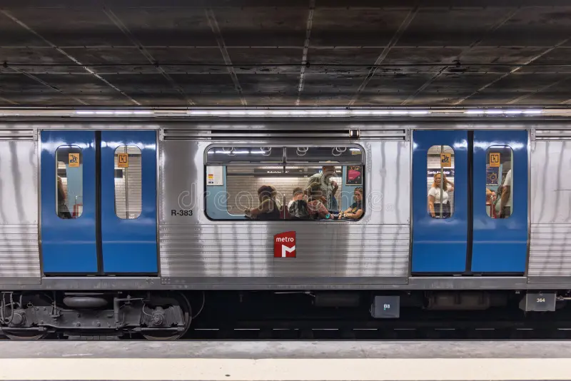 A side view of a metro train stopped at a station platform, with its doors open. Passengers are visible inside the train and on the platform. Lisbon, Portugal. 1 August 2025. Side subway train view stock images, royalty-free photos and pictures