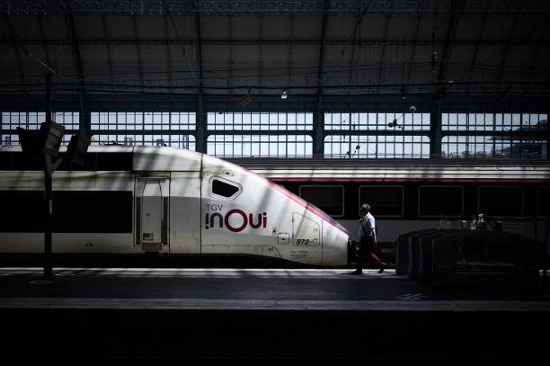 Man walks past a TGV train at the railway station in Bordeaux, southwestern France, on June 15, 2022 as a heatwave hits France. - France's weather...