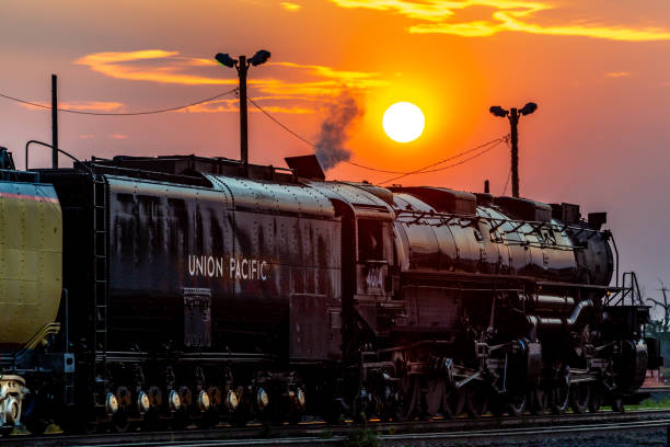 Union Pacific Big Boy Sunrise Sidney, NE - August 6, 2021: Union Pacific's largest steam locomotive, wheel arrangement 4-8-8-4, number 4014 basks in the sunrise at Sidney, NE, early on a tour during 2021. union pacific railroad stock pictures, royalty-free photos & images